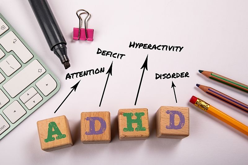 ADHD - Attention Deficit Hyperactivity Disorder. Wooden blocks on a white office table.